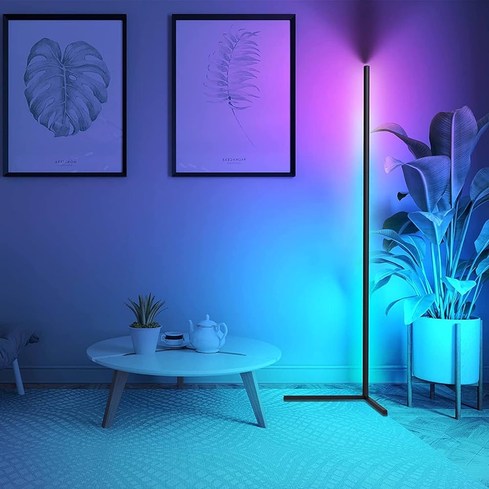 Living room with a floor lamp casting a purple glow, plants, and framed artwork on the wall.