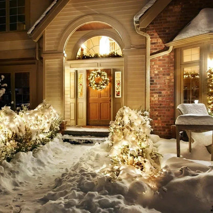 Decorated house entrance with wreath and lights in a snowy setting