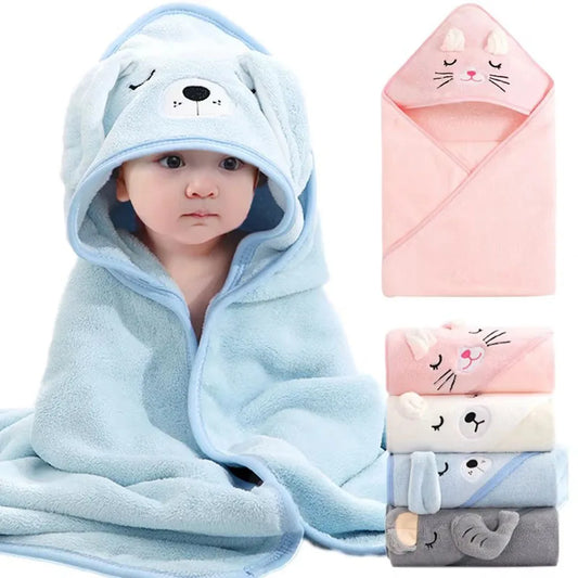 Baby wearing a blue hooded towel with animal face design, surrounded by additional towels in pink, white, and gray.