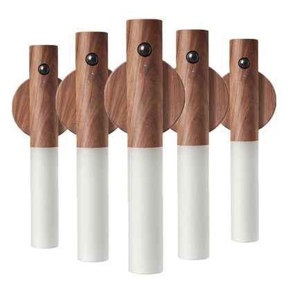 Set of five wooden cordless wall lights with white bases on a white background